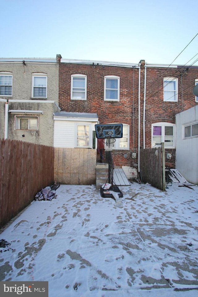 view of snow covered rear of property