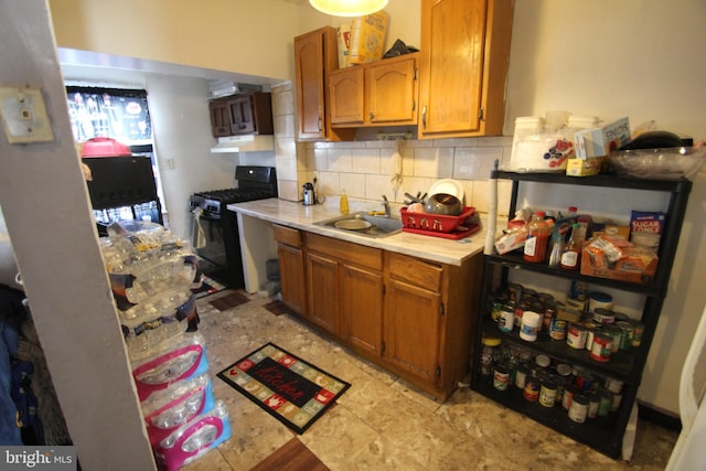 kitchen featuring tasteful backsplash, sink, and black range with gas stovetop