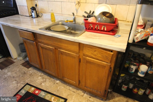 kitchen featuring tasteful backsplash, sink, and black stove