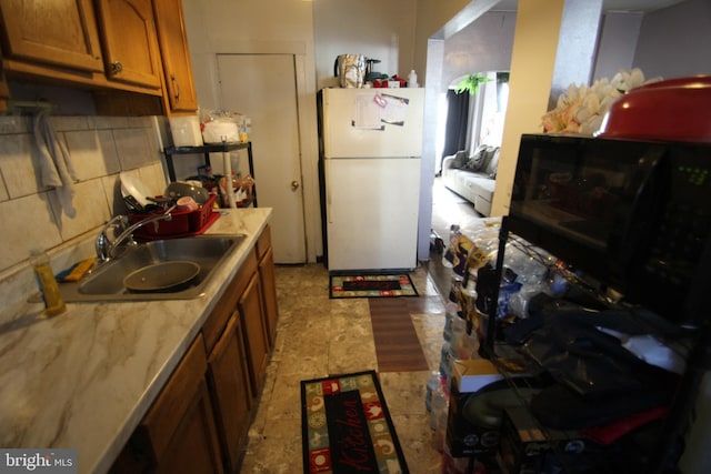 kitchen with sink, white fridge, and backsplash