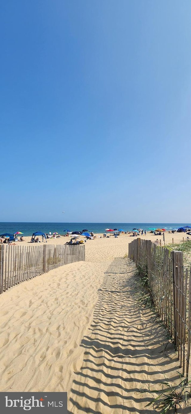 view of water feature with fence and a view of the beach