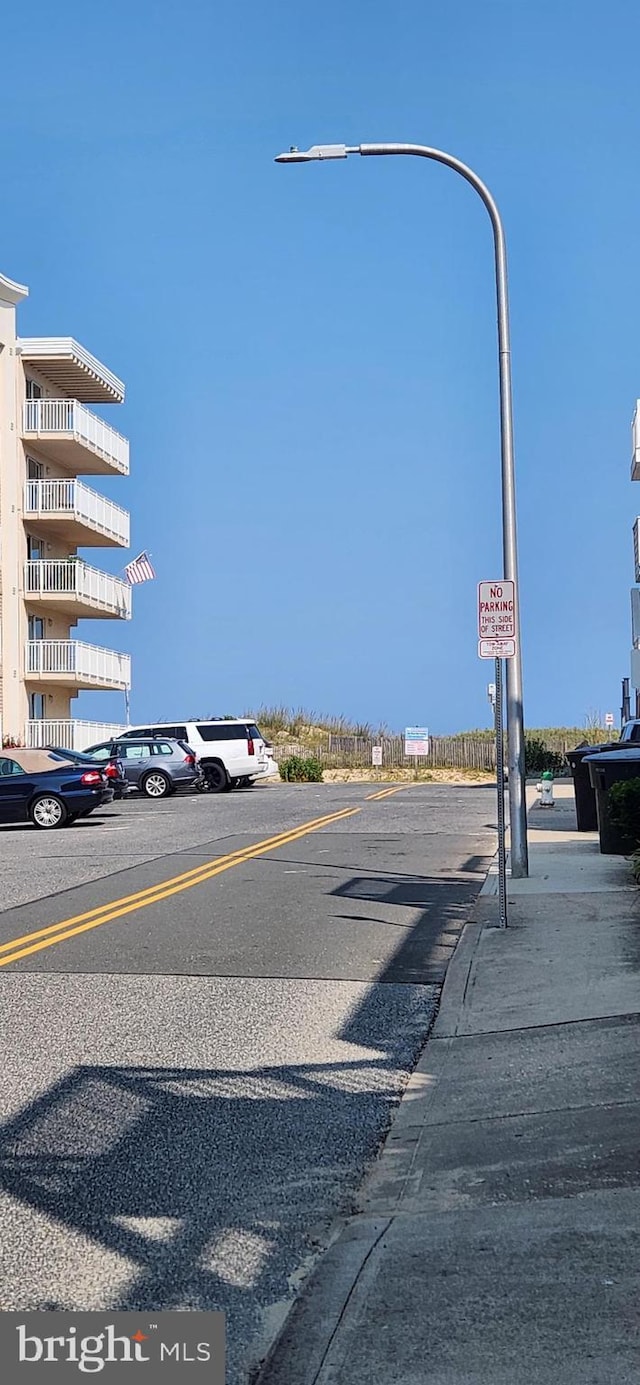 view of road featuring street lighting, curbs, and sidewalks