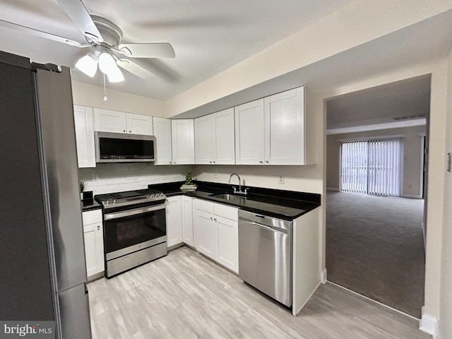 kitchen featuring stainless steel appliances, sink, and white cabinets