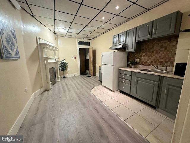 kitchen featuring sink, backsplash, gray cabinets, and white refrigerator