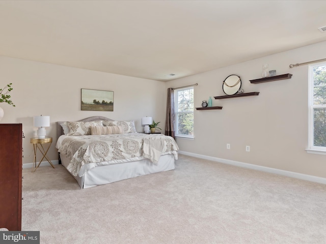 carpeted bedroom featuring multiple windows