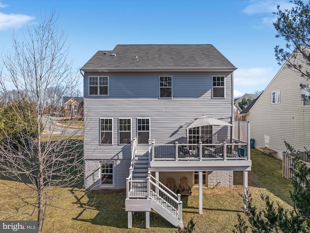 rear view of house with a deck and a lawn