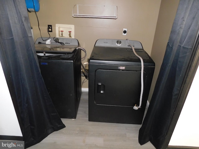 washroom with laundry area, separate washer and dryer, and wood finished floors