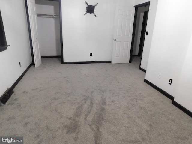 unfurnished bedroom with a closet, carpet, and baseboards