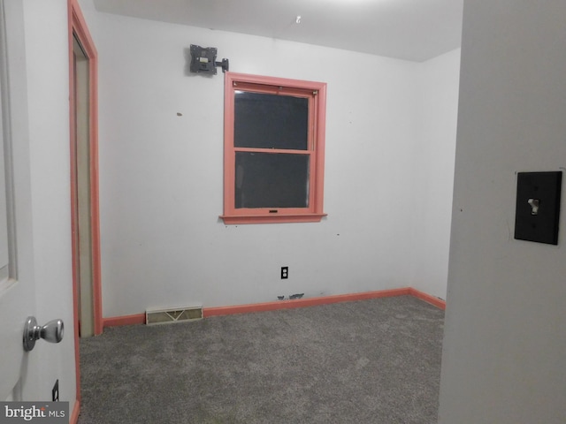 carpeted empty room featuring baseboards and visible vents