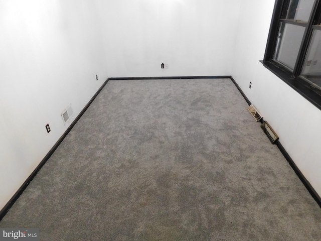 unfurnished room featuring carpet floors, baseboards, and visible vents