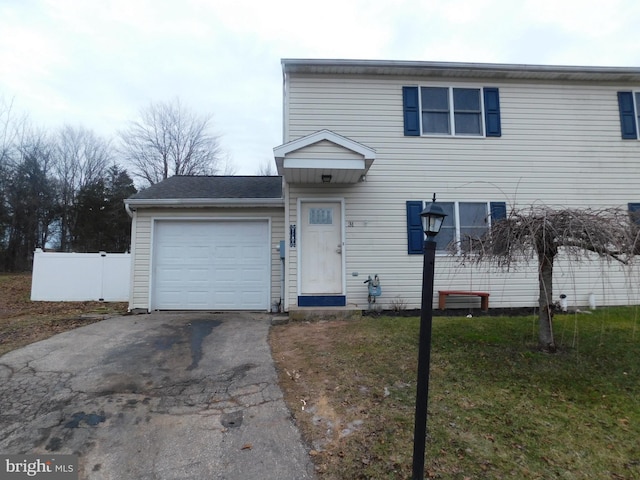 view of front of property with a garage, a front yard, driveway, and fence