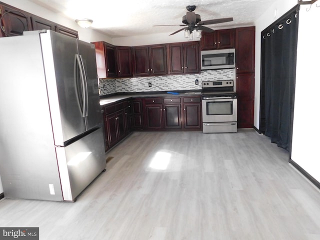 kitchen with decorative backsplash, dark countertops, ceiling fan, stainless steel appliances, and light wood-type flooring