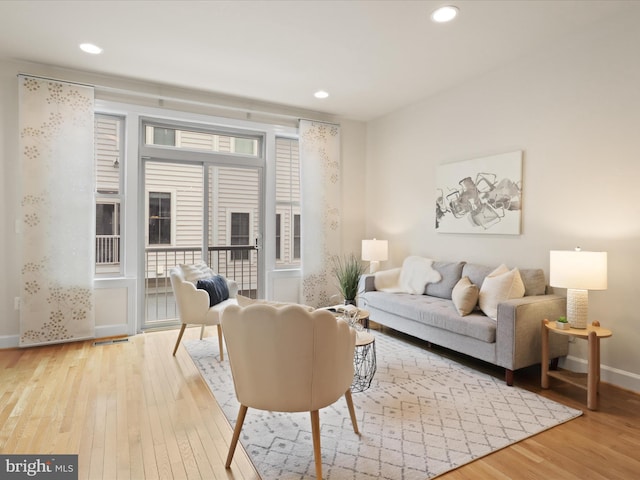 living area featuring hardwood / wood-style floors, recessed lighting, and baseboards