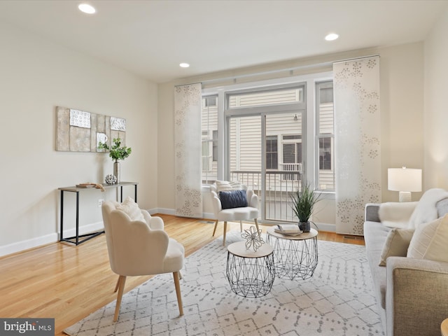 living area with recessed lighting, wood finished floors, and baseboards