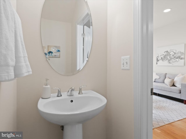 bathroom with a sink, wood finished floors, and recessed lighting