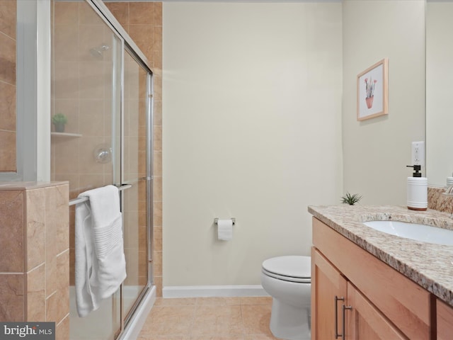 bathroom with toilet, a shower stall, tile patterned flooring, baseboards, and vanity