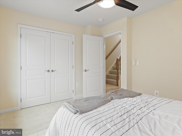 carpeted bedroom with a closet, baseboards, and ceiling fan