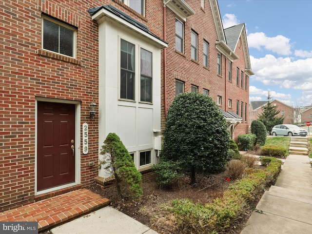 property entrance featuring brick siding