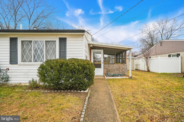 view of front of house featuring a sunroom and a front yard