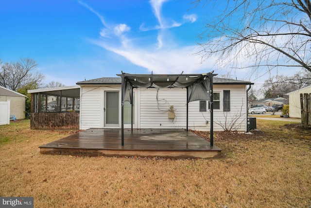 back of house with central AC unit, a lawn, a sunroom, and a deck