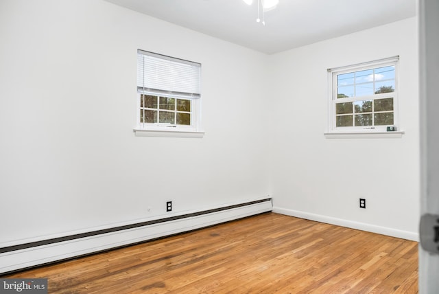 unfurnished room featuring light hardwood / wood-style floors, ceiling fan, and baseboard heating