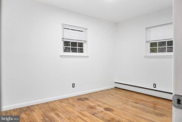 spare room featuring a baseboard radiator and light hardwood / wood-style flooring