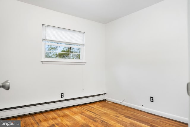 unfurnished room with light hardwood / wood-style flooring and a baseboard heating unit