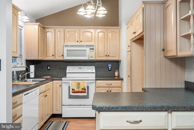 kitchen with vaulted ceiling, light brown cabinetry, decorative light fixtures, sink, and white appliances