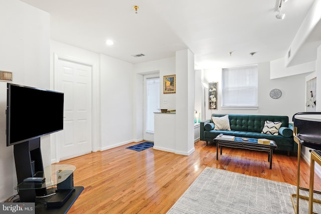 living room with hardwood / wood-style floors and track lighting