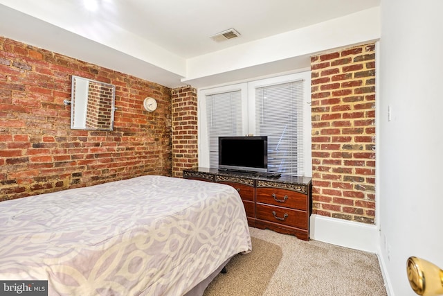 bedroom with brick wall and light colored carpet