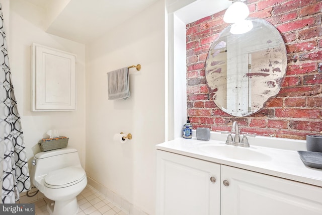 bathroom featuring vanity, tile patterned flooring, toilet, and brick wall