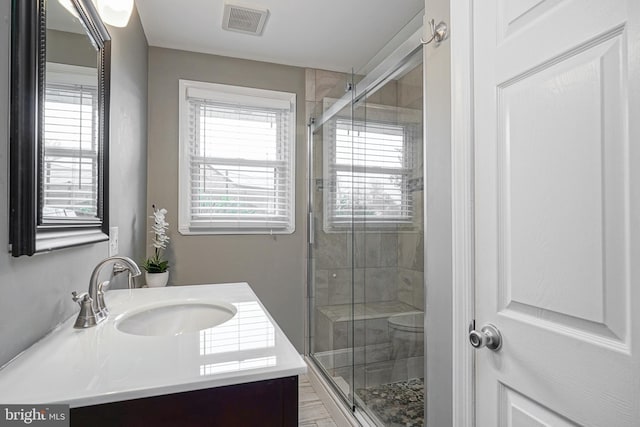 bathroom featuring a shower stall, visible vents, and a wealth of natural light