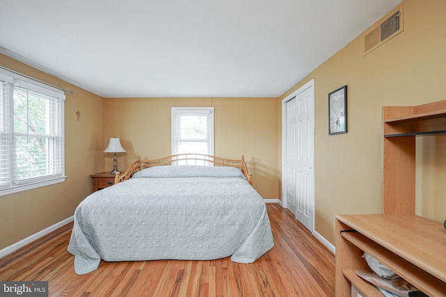 bedroom featuring wood finished floors, visible vents, and baseboards