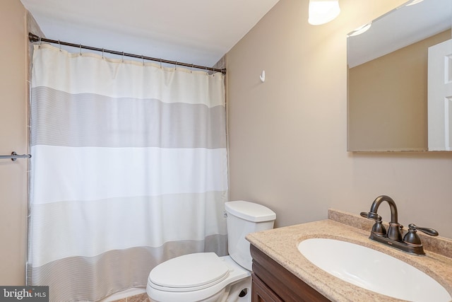 bathroom with a shower with shower curtain, vanity, and toilet