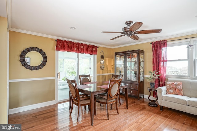 dining room featuring crown molding, light wood-style flooring, and baseboards