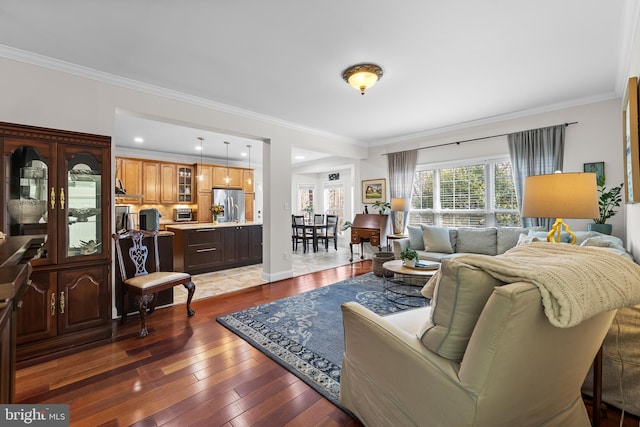 living room featuring wood-type flooring, ornamental molding, and baseboards