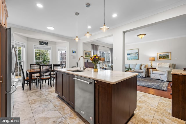 kitchen featuring appliances with stainless steel finishes, open floor plan, crown molding, and a sink