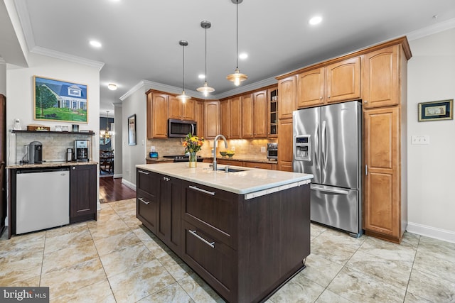 kitchen with glass insert cabinets, appliances with stainless steel finishes, ornamental molding, hanging light fixtures, and a sink