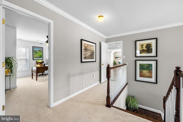 hallway with light carpet, baseboards, an upstairs landing, and crown molding