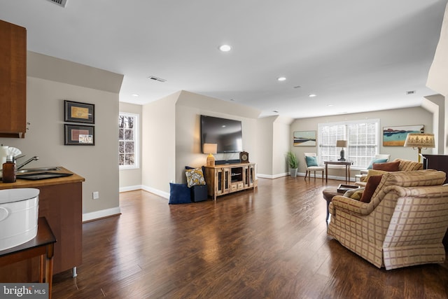 living area featuring visible vents, baseboards, dark wood finished floors, and recessed lighting