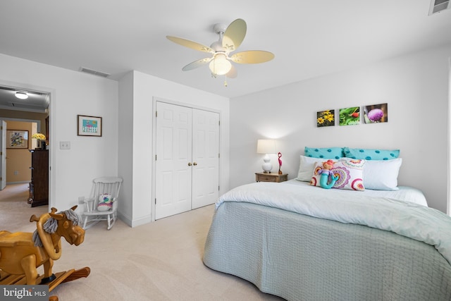 bedroom featuring a closet, visible vents, light carpet, ceiling fan, and baseboards