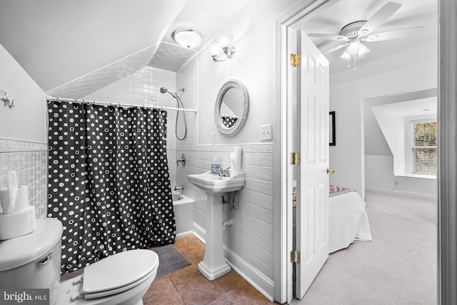 bathroom featuring a wainscoted wall, tile walls, toilet, ceiling fan, and tile patterned floors