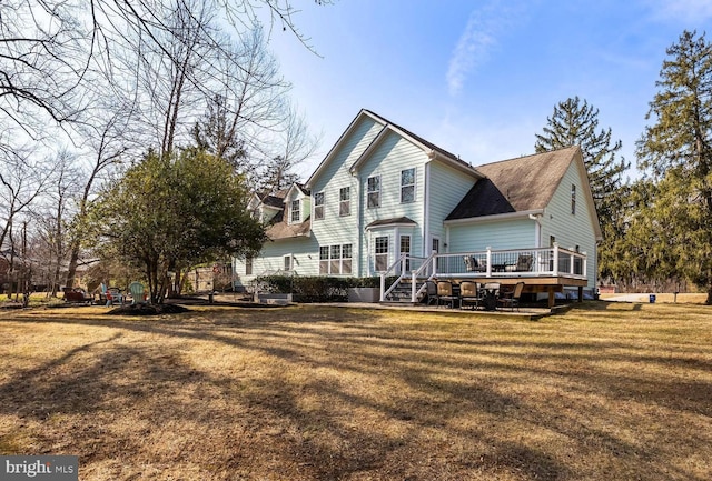 back of house featuring a lawn and a wooden deck