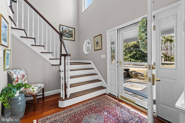 foyer with stairway, wood finished floors, and baseboards