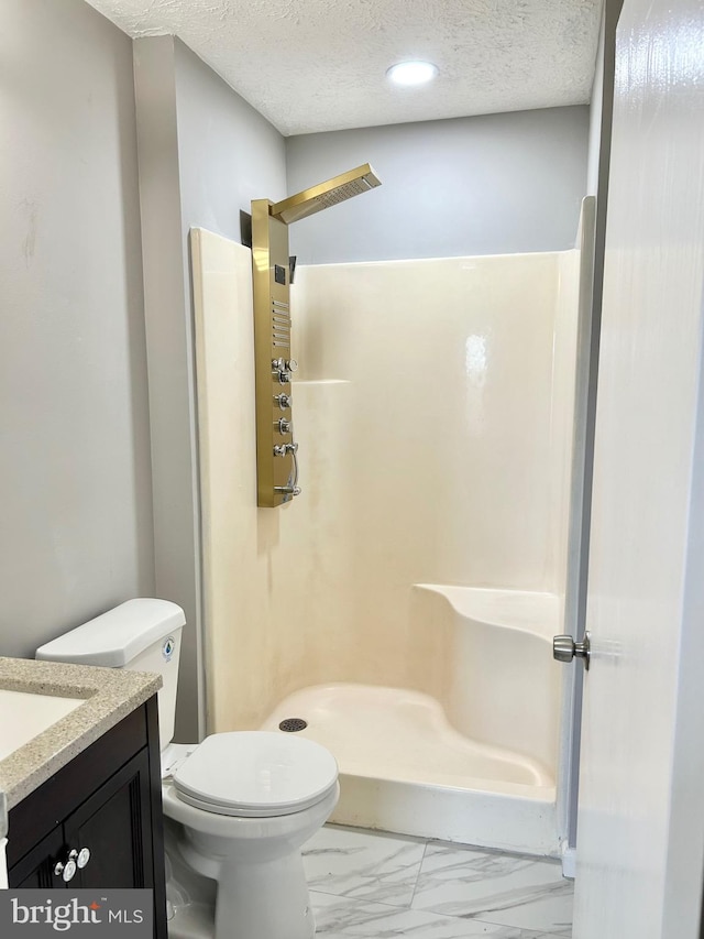 bathroom featuring vanity, toilet, a textured ceiling, and walk in shower