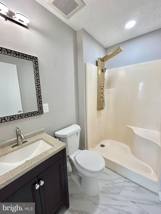 bathroom with vanity, walk in shower, a textured ceiling, and toilet