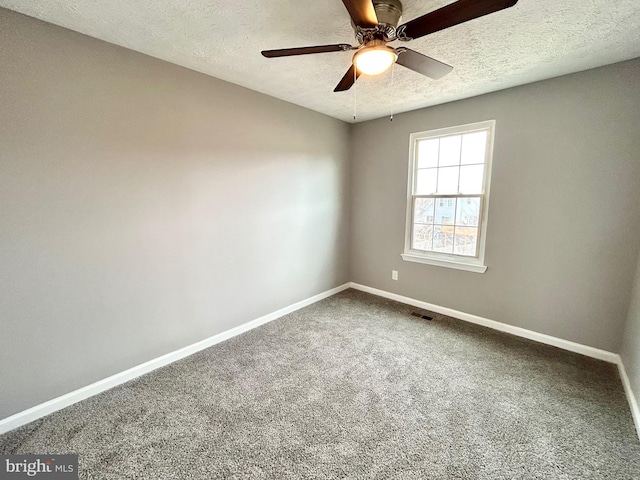 empty room featuring ceiling fan, carpet floors, and a textured ceiling