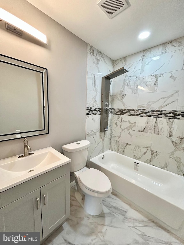 full bathroom with tiled shower / bath, vanity, and toilet