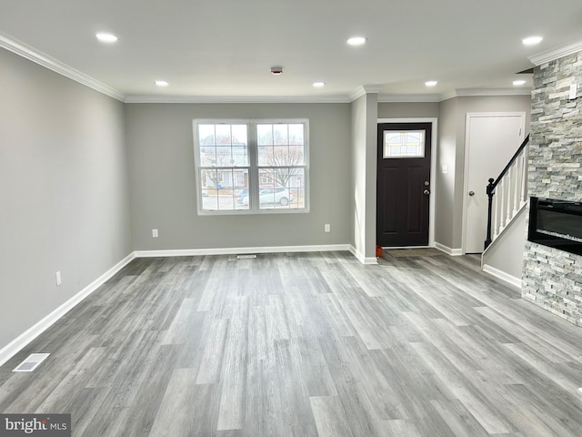 entryway featuring ornamental molding and light hardwood / wood-style flooring