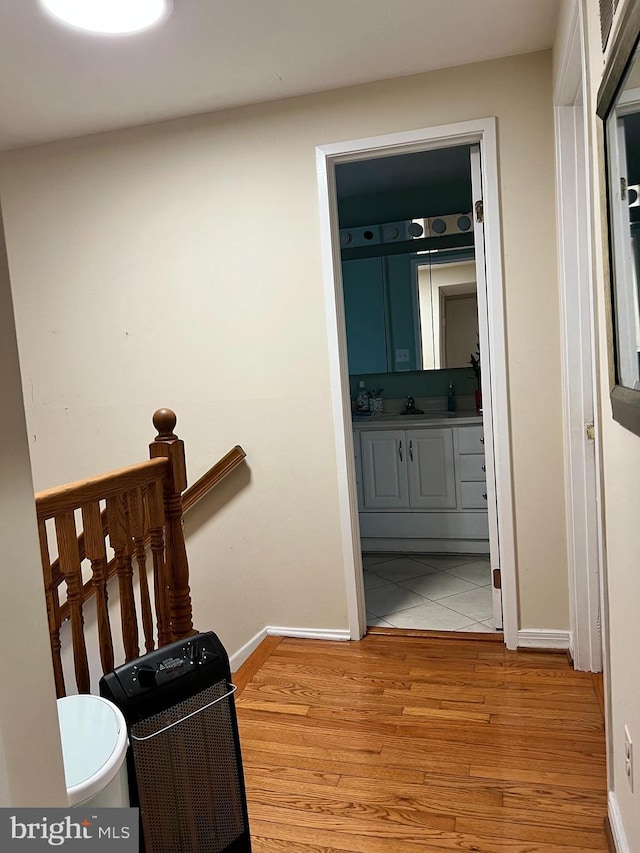 hallway with sink and light hardwood / wood-style floors